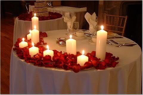 Candlelit sweetheart table with rose petals