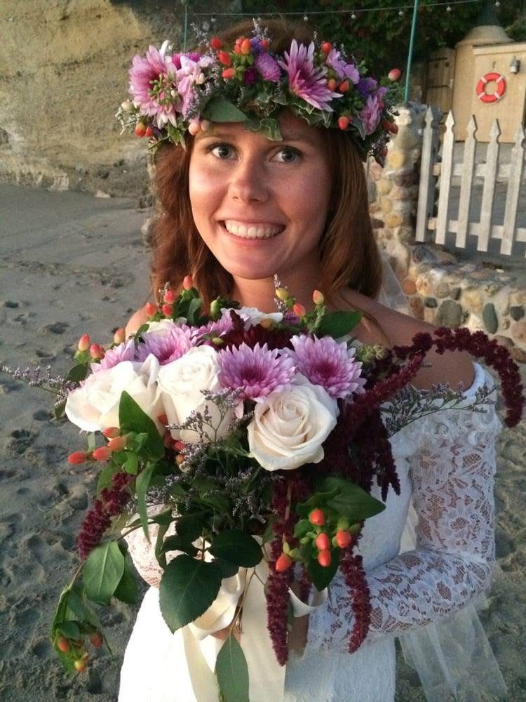 Bride wearing a floral crown and holding a handcrafted bouquet